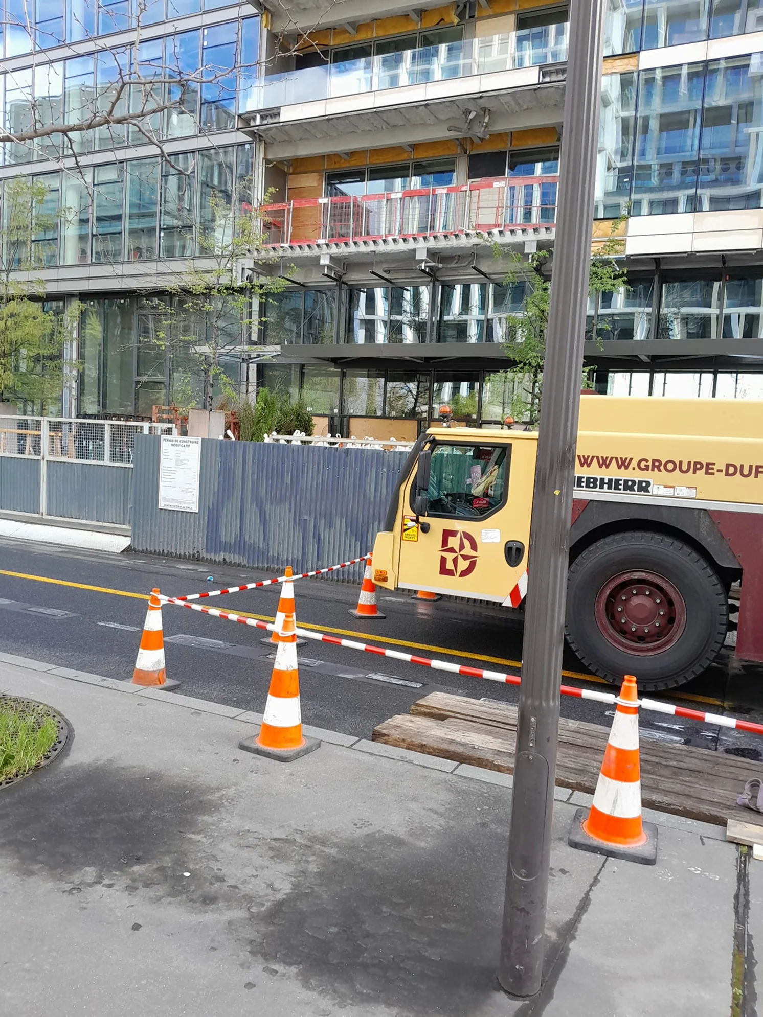 Grue et zone de chantier délimitée par des cônes